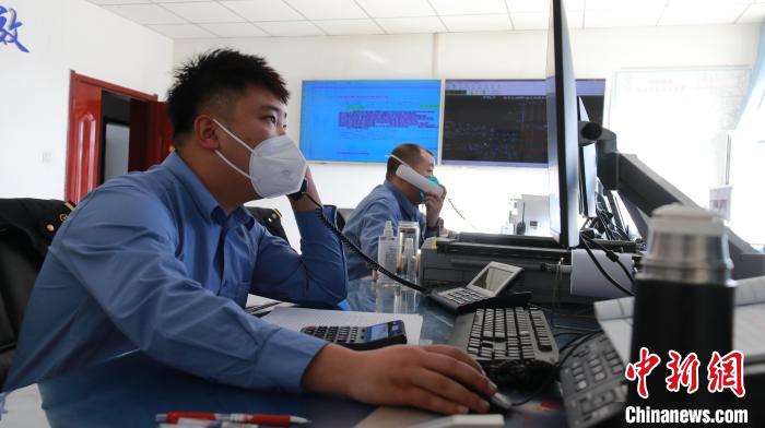圖為貨運(yùn)調(diào)度人員與外勤工作人員聯(lián)系掌握車輛裝載情況?！±钌?攝