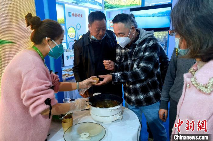 圖為杭州市民品嘗茶卡羊肉?！±铍h 攝