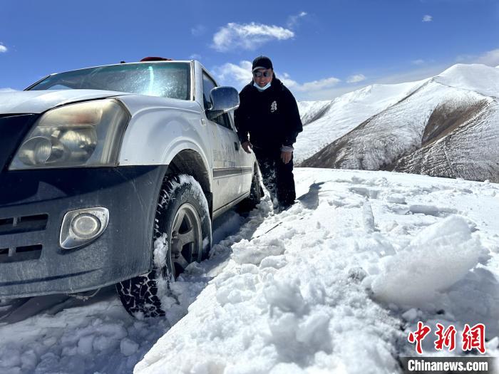圖為生態(tài)管護人員準備在雪地推車?！《“瓦_杰 攝