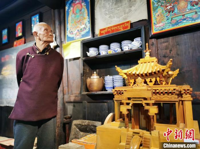 圖為古堡內(nèi)的藝人桑杰展示自己的雕刻作品?！?zhí)砀?攝