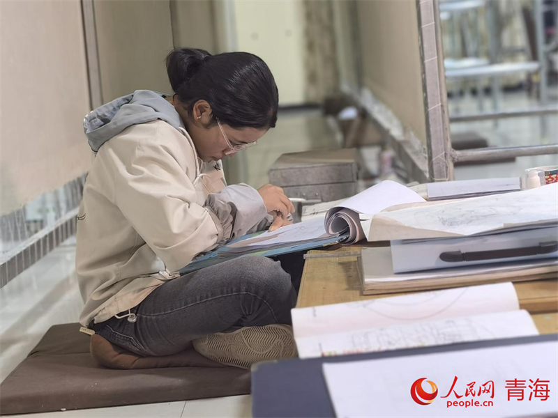 正在學(xué)習(xí)畫底稿的尕讓旺姆。人民網(wǎng) 陳明菊攝