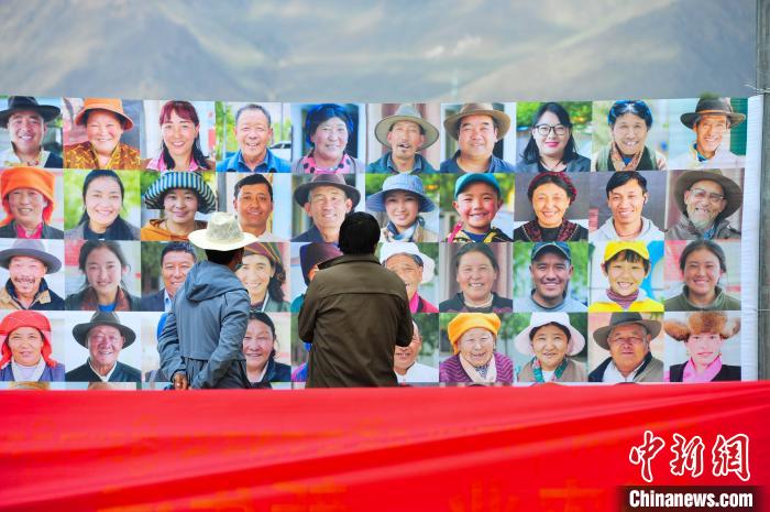 圖為當(dāng)?shù)孛癖娫谟^看展板上的笑臉?！垈?攝