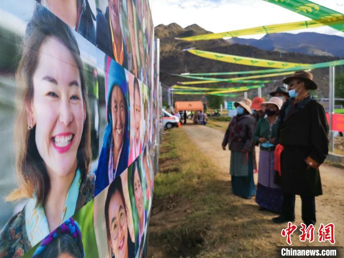 圖為當(dāng)?shù)孛癖娫谟^看展板上的笑臉?！垈?攝
