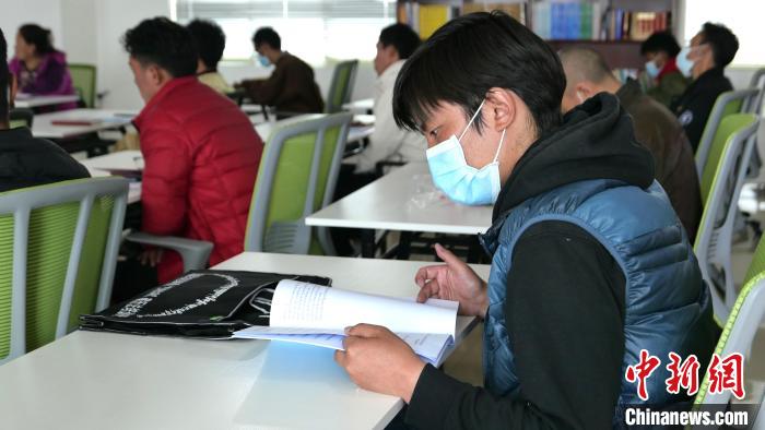 圖為正在閱讀“杰松達(dá)孜”藏歷法教材的學(xué)員?！≈x牧 攝