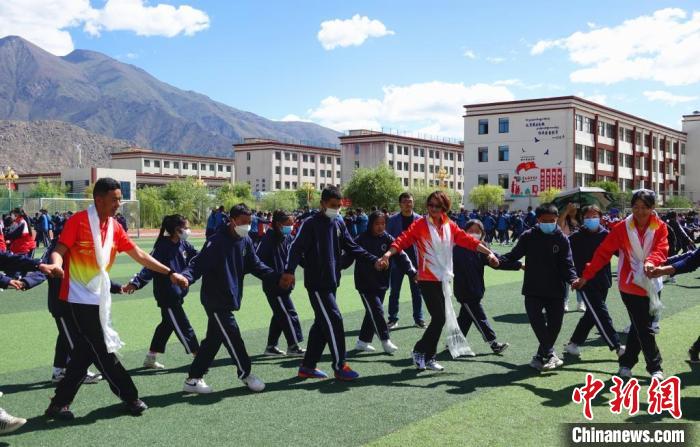 圖為世界冠軍與拉薩阿里地區(qū)高級(jí)中學(xué)學(xué)生一起跳鍋莊。　冉文娟 攝