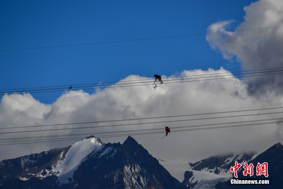 資料圖為2020年6月23日，西藏阿里聯(lián)網工程施工人員在日喀則希夏邦馬雪山附近進行走線作業(yè)，安裝絕緣設備。 <a target='_blank' href='/'><p  align=