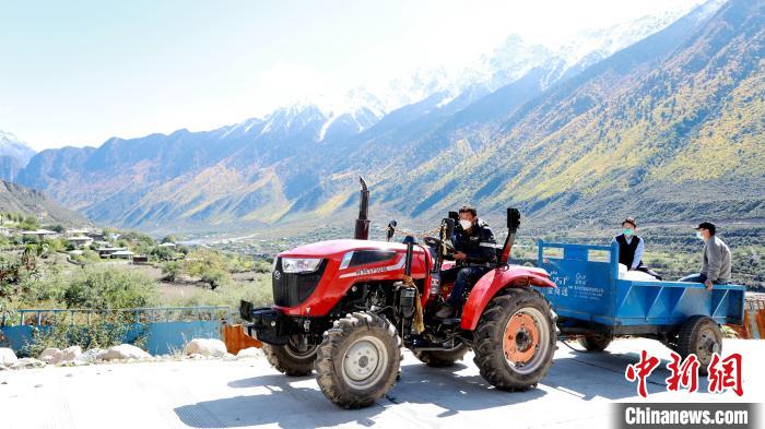 圖為工作人員將把加工完成的糌粑運(yùn)送至村民手中。　嘉黎縣融媒體中心供圖