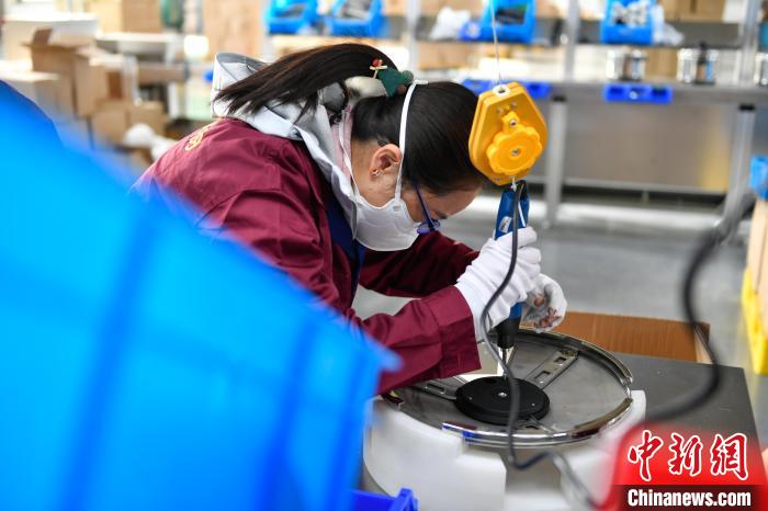 圖為工人正在組裝炊具?！∝暩聛硭?攝