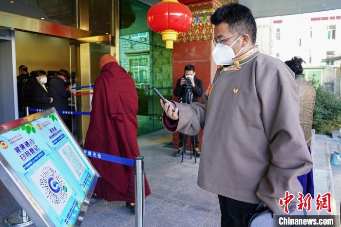 圖為政協(xié)委員掃場(chǎng)所碼進(jìn)入會(huì)場(chǎng)?！〗w波 攝