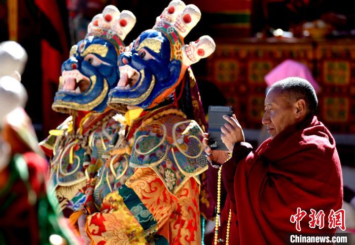 2月19日，正在拍攝跳神活動的僧人?！±盍?攝