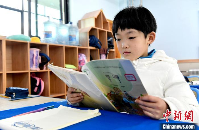 3月14日，西藏拉薩市第一小學(xué)一年級(jí)六班學(xué)生丁增樂(lè)吉在閱讀藏語(yǔ)課本?！±盍?攝