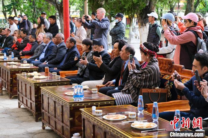 5月19日，中外嘉賓在羅布林卡和游客一起觀看藏戲?！〗w波 攝