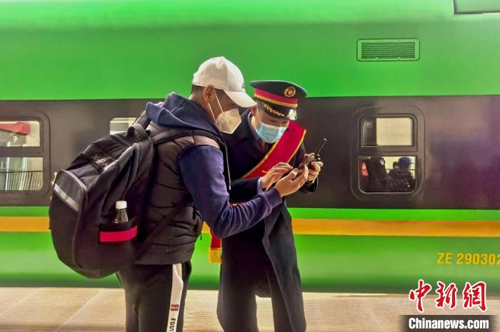 圖為日喀則火車站工作人員服務(wù)乘客?！《飞降?攝