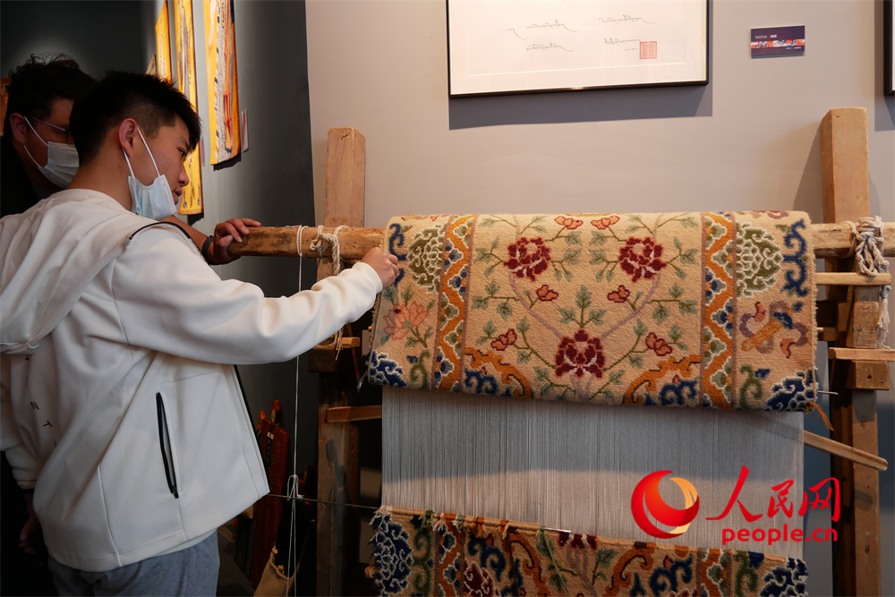 觀眾正在觀賞展出的藏毯。人民網(wǎng) 韋衍行攝