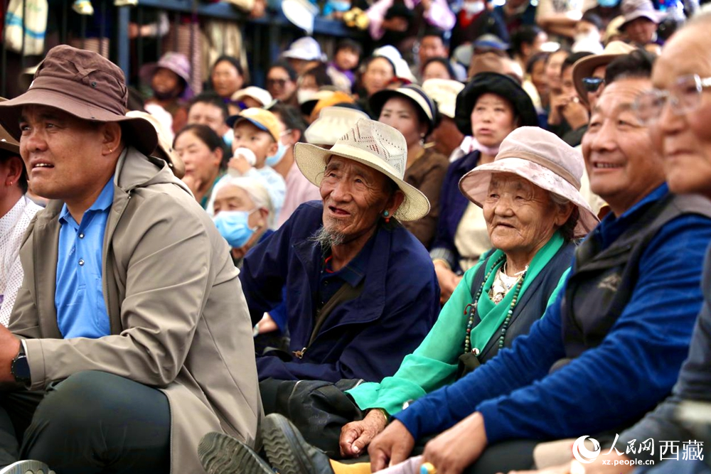 當(dāng)?shù)厝罕姾陀慰陀^看藏戲演出。