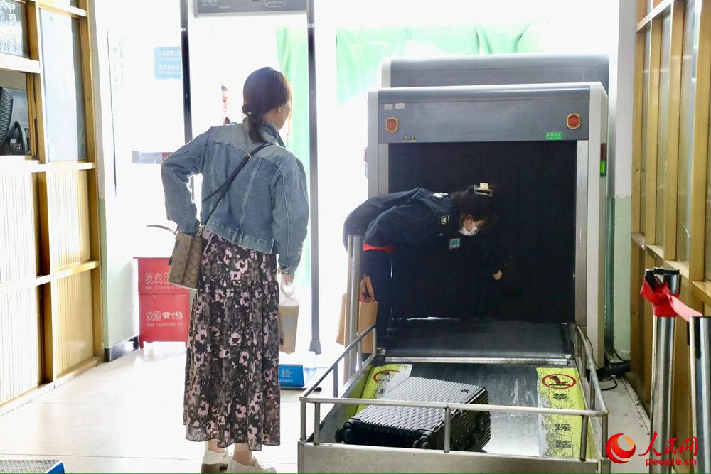 車(chē)站工作人員幫旅客提取行李。人民網(wǎng)記者 次仁羅布攝