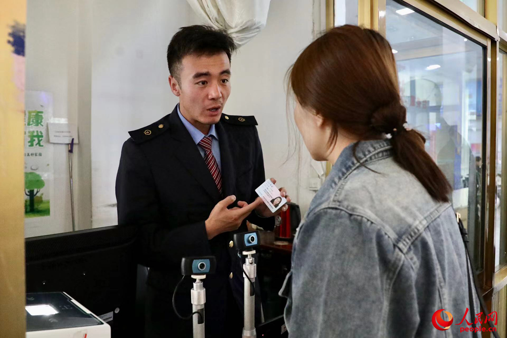 車(chē)站工作人員向旅客解答疑問(wèn)。人民網(wǎng)記者 次仁羅布攝