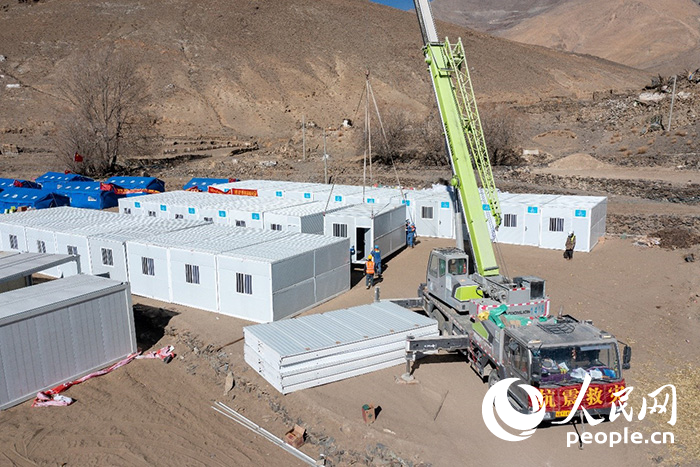 1月9日，在日喀則市定日縣長所鄉(xiāng)古榮村安置點，救援人員和施工人員合力抓緊搭建移動板房，確保受災(zāi)群眾溫暖過冬。人民網(wǎng)記者 翁奇羽攝