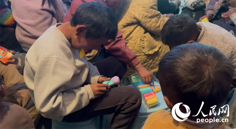 措果鄉(xiāng)塘仁村的孩子們正在用橡皮泥制作自己的情緒“小怪獸”。人民網(wǎng)記者 郝潔攝