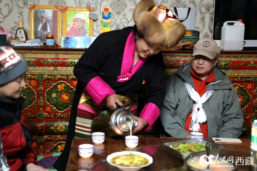 扎西曲登社區(qū)的居民在家中熱情招待遠(yuǎn)道而來的游客。居民身著盛裝，為游客倒上熱騰騰的酥油茶，桌上擺放著切瑪與特色美食，賓主共話民族團(tuán)結(jié)情誼。人民網(wǎng)記者 吳雨仁攝