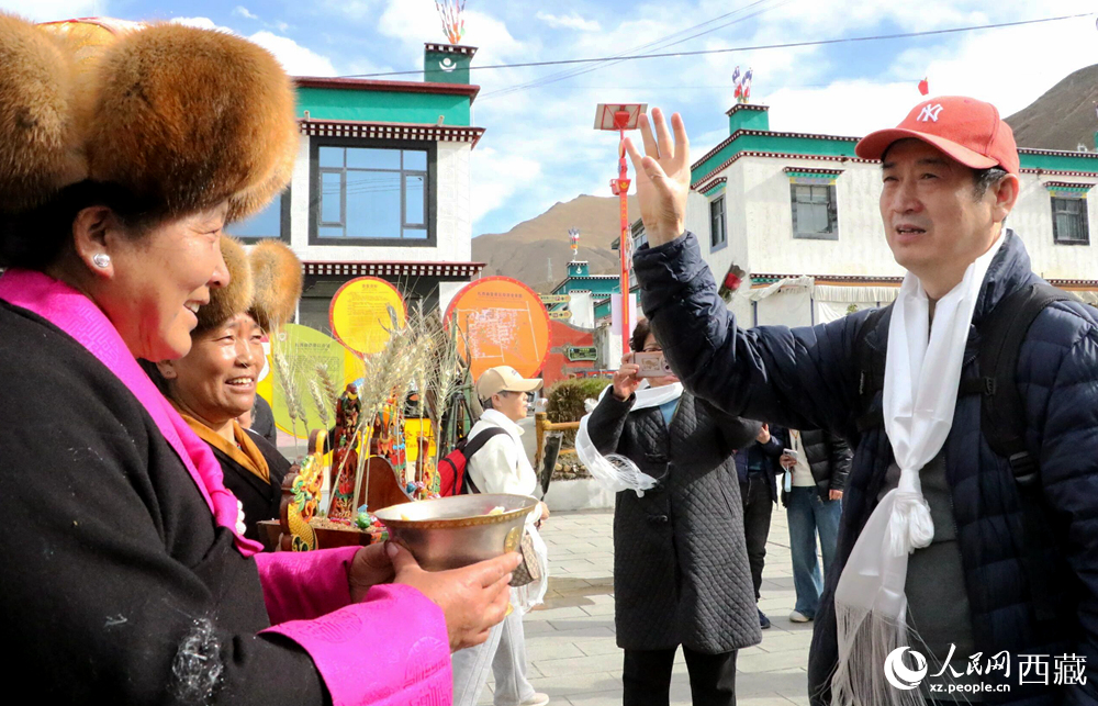 藏族同胞向游客敬獻青稞酒。人民網(wǎng)記者 吳雨仁攝