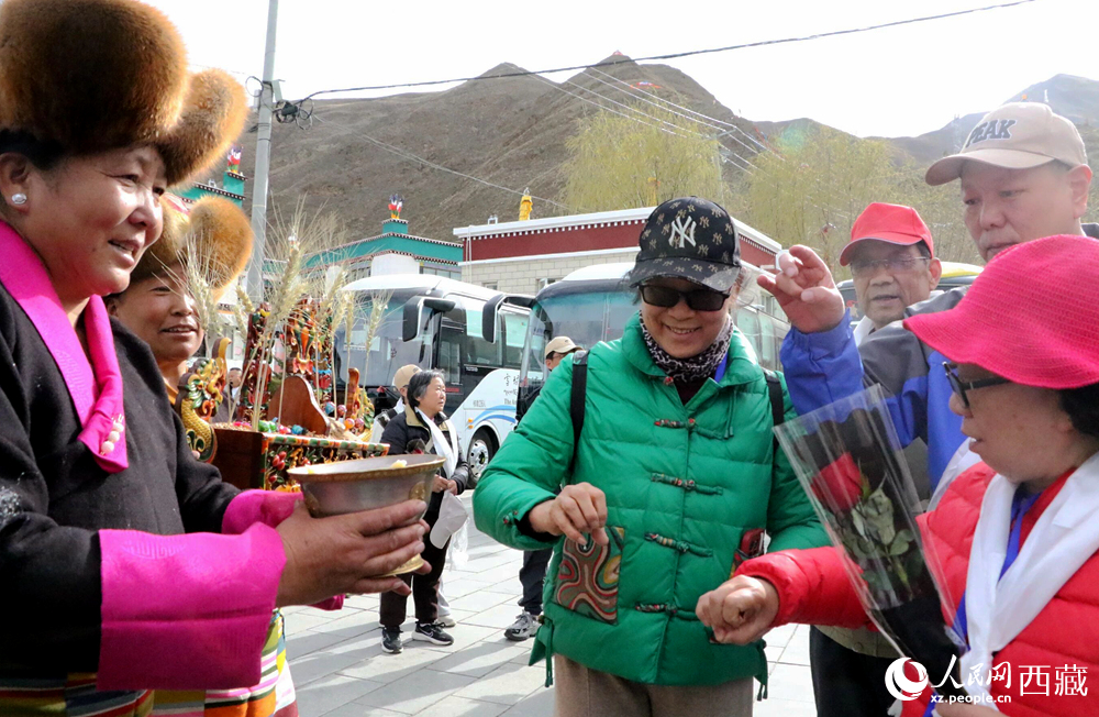 藏族同胞向游客敬獻青稞酒。人民網(wǎng)記者 吳雨仁攝