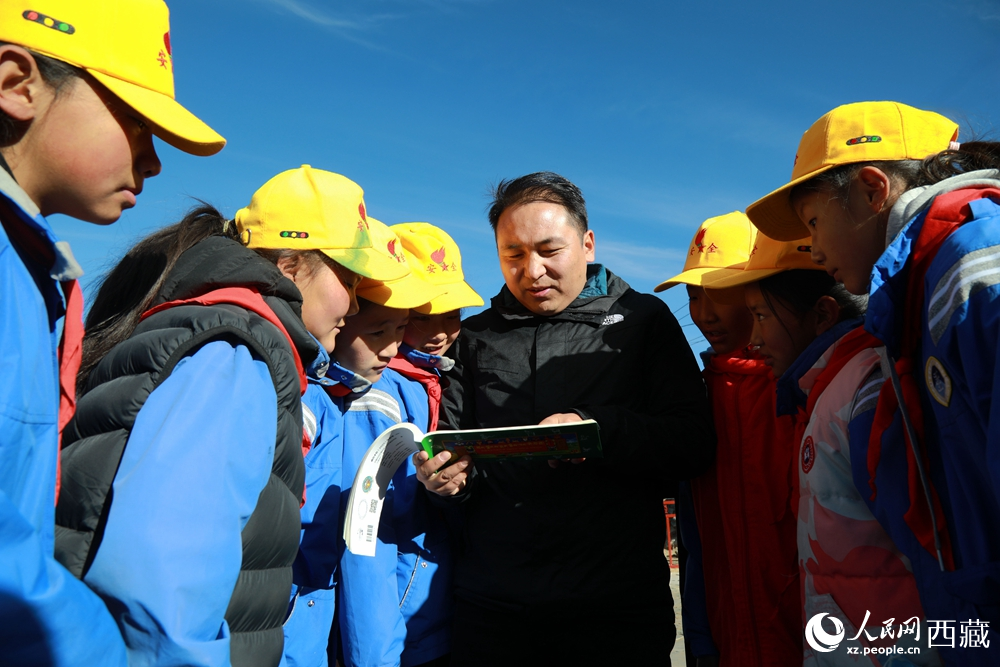 西藏自治區(qū)藏醫(yī)院專(zhuān)家為拉東村小學(xué)生講解天文歷算原理，孩子們圍站聆聽(tīng)，感受傳統(tǒng)智慧與現(xiàn)代科普的融合。人民網(wǎng)記者 吳雨仁攝