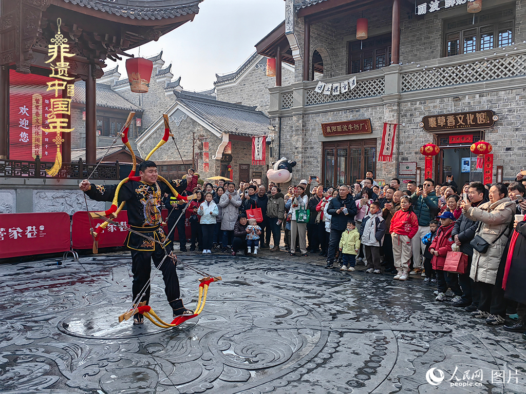 2025年1月29日，湖北襄陽(yáng)市管家巷，老北京天橋大刀張舉大刀拉硬弓第五代傳承人現(xiàn)場(chǎng)表演，一次拉開(kāi)6張弓，引來(lái)游客喝彩。人民網(wǎng)記者 郭婷婷攝