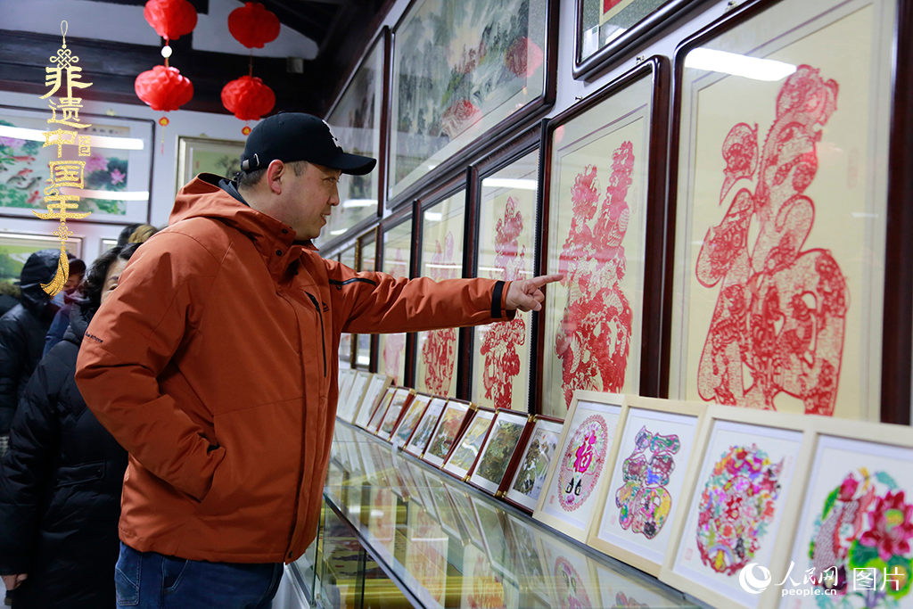 2025年1月23日，游客在天津楊柳青古鎮(zhèn)欣賞傳統(tǒng)剪紙作品，感受指尖上的古老藝術(shù)。人民網(wǎng)記者 崔新耀攝