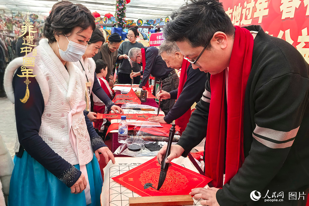 新春佳節(jié)之際，長(zhǎng)春農(nóng)博園冬季展會(huì)火熱進(jìn)行，展廳內(nèi)，書法家現(xiàn)場(chǎng)書寫“?！弊郑忻裼慰图娂娚锨坝航印案！薄Ｈ嗣窬W(wǎng)記者 王海躍攝