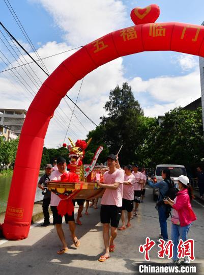 圖為5月29日，長樂江田鎮(zhèn)村民們推著新龍舟前行。　張斌 攝