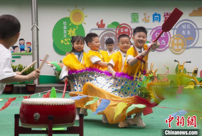 圖為龍舟賽游戲上，小伙伴們打鼓加油?！《^生 攝